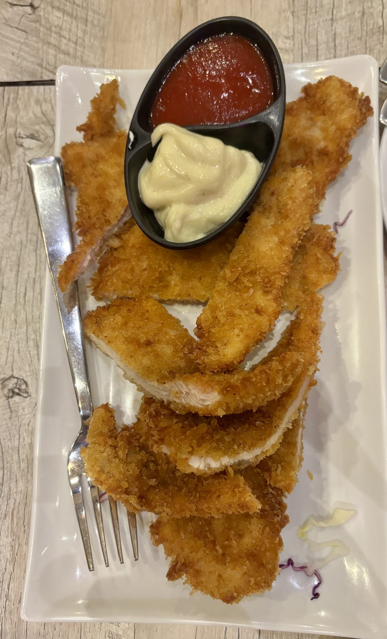 Golden crispy breaded chicken strips with dipping sauces